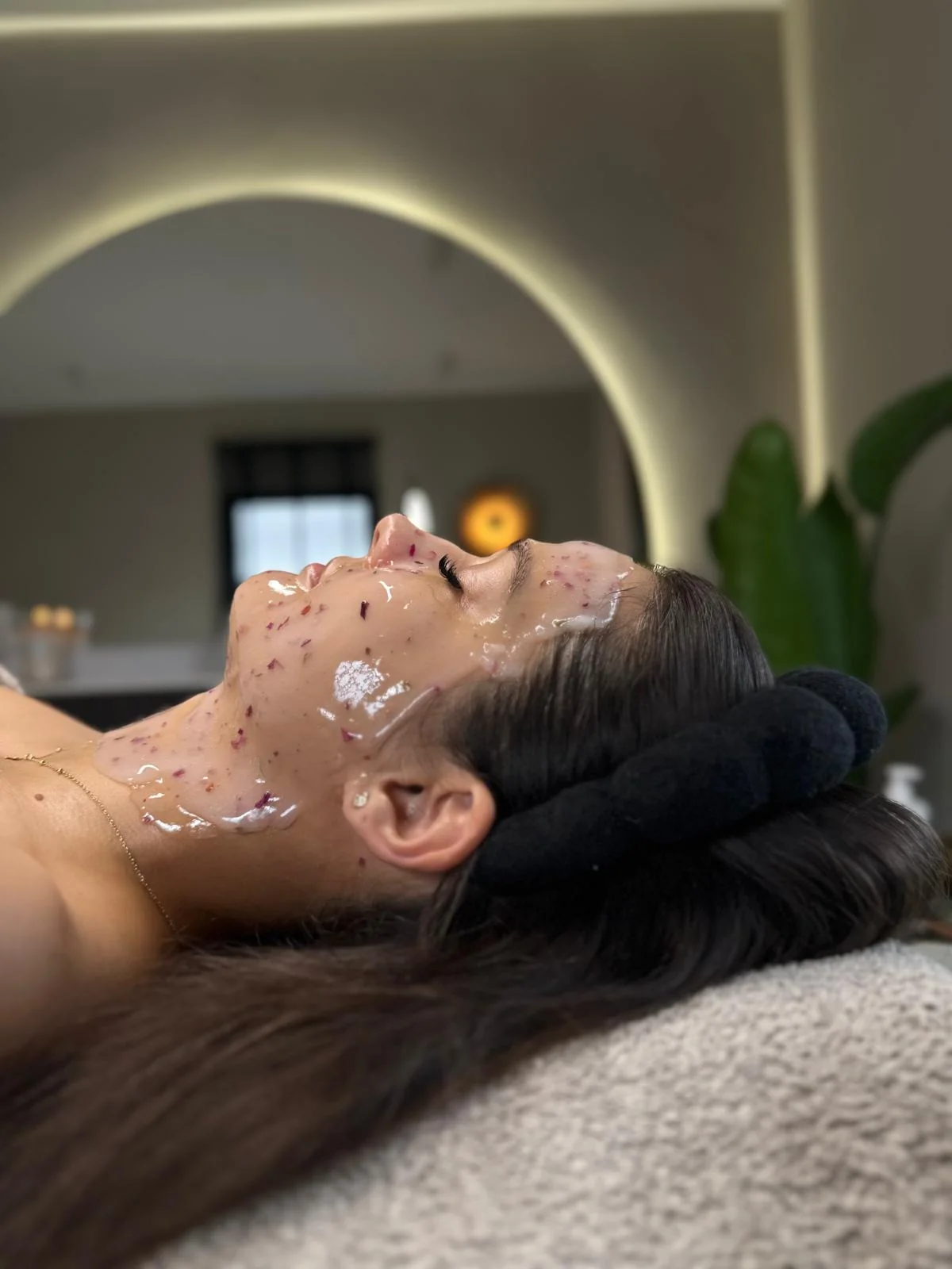 Klientka podczas zabiegu z maską z płatkami w gabinecie Ritual Clinic