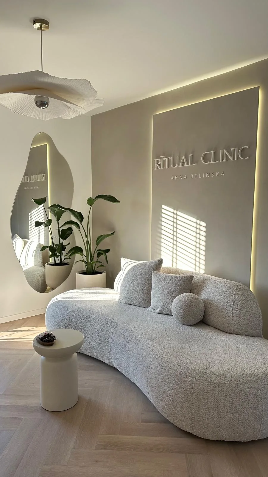 Poczekalnia Ritual Clinic z podświetlonym logo na ścianie